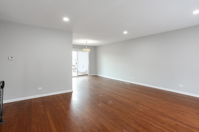 spare room featuring dark wood-style floors, recessed lighting, and baseboards