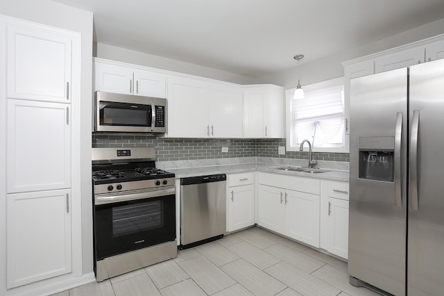 kitchen featuring white cabinets, stainless steel appliances, and a sink