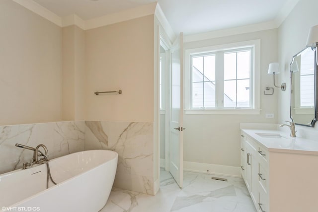 full bath with vanity, tile walls, marble finish floor, wainscoting, and a soaking tub