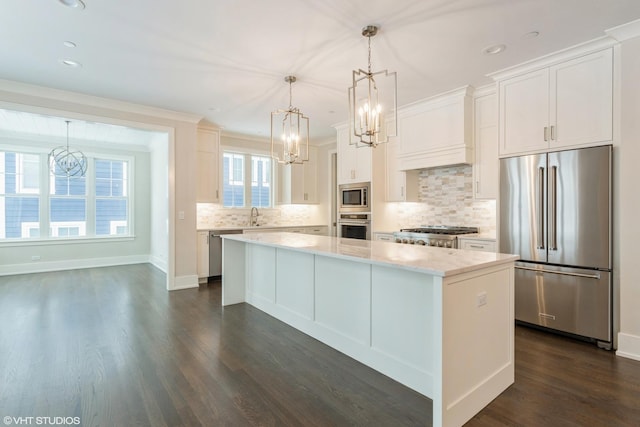 kitchen featuring stainless steel appliances, a center island, white cabinetry, and decorative light fixtures