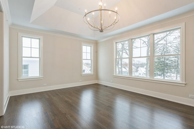 empty room featuring baseboards, a raised ceiling, dark wood-style flooring, and a chandelier