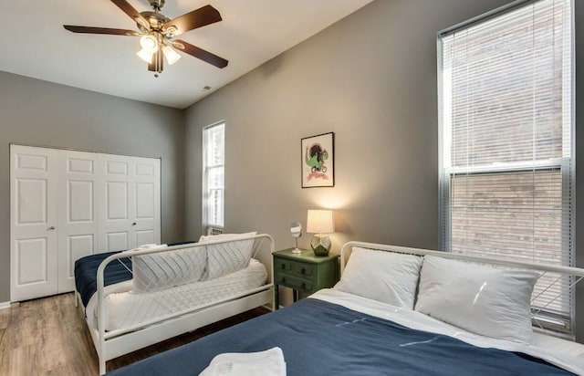 bedroom featuring light wood-style flooring, a ceiling fan, and a closet