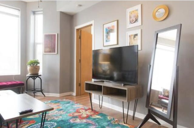 living area with light wood-style flooring and baseboards