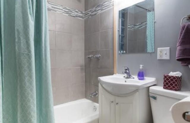 full bathroom with toilet, shower / bath combo, and vanity