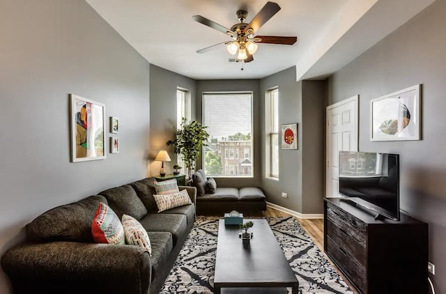 living area featuring ceiling fan, wood finished floors, and baseboards