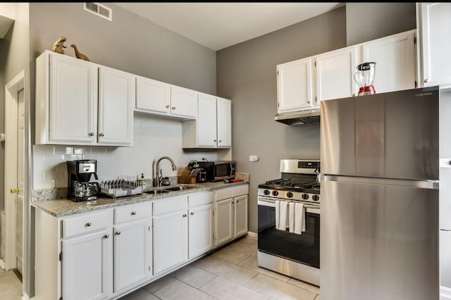 kitchen featuring light stone counters, a sink, visible vents, white cabinets, and appliances with stainless steel finishes