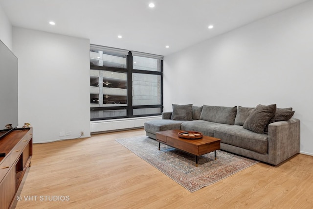 living area with light wood-type flooring and recessed lighting