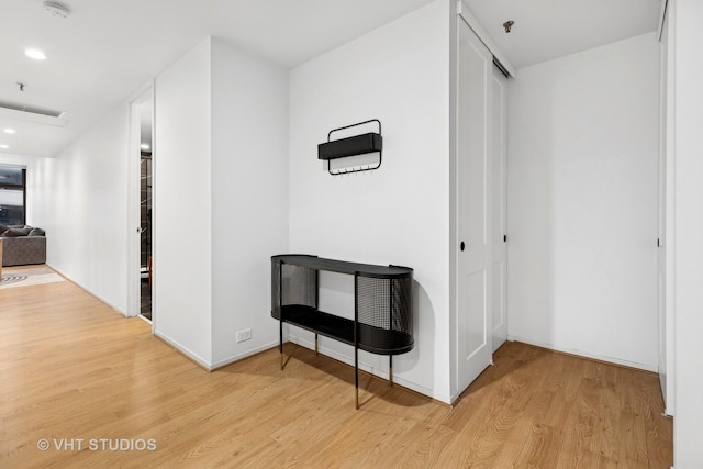 hall with baseboards, recessed lighting, and light wood-style floors