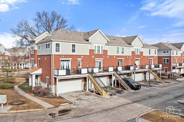 view of building exterior with a garage, stairs, and a residential view