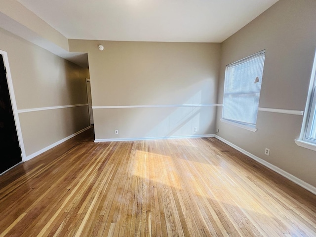 unfurnished room with baseboards and wood finished floors