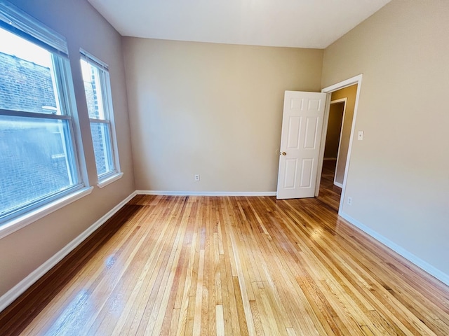 empty room featuring light wood-type flooring and baseboards