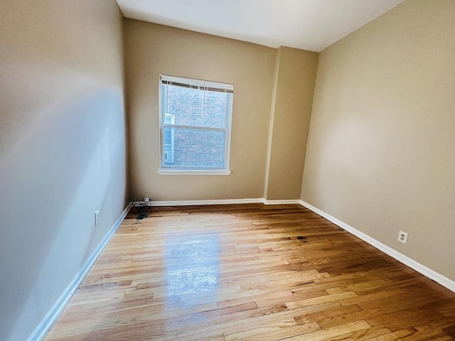 unfurnished room featuring light wood-type flooring and baseboards