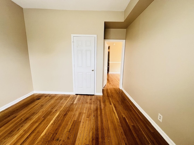 unfurnished bedroom with baseboards and wood finished floors