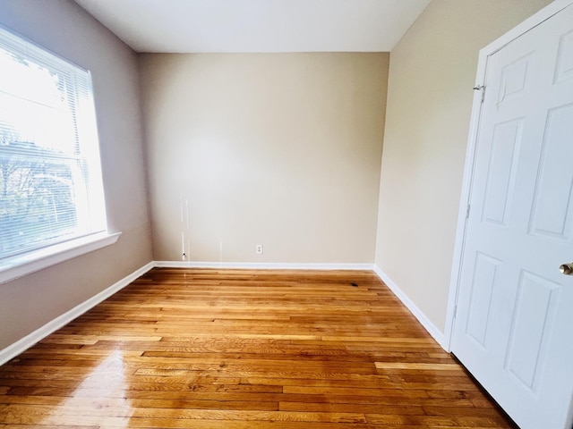 spare room featuring light wood finished floors and baseboards