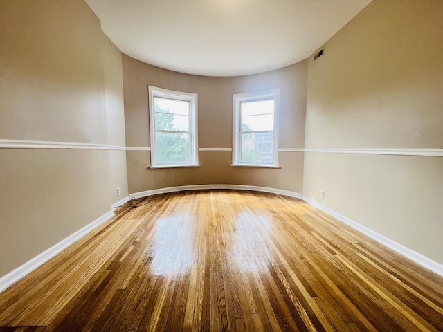 spare room with light wood-type flooring, baseboards, and visible vents