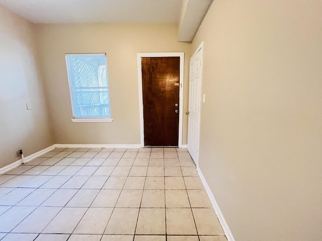 unfurnished room featuring light tile patterned floors and baseboards