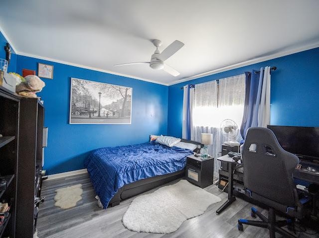 bedroom featuring ceiling fan, crown molding, and wood finished floors