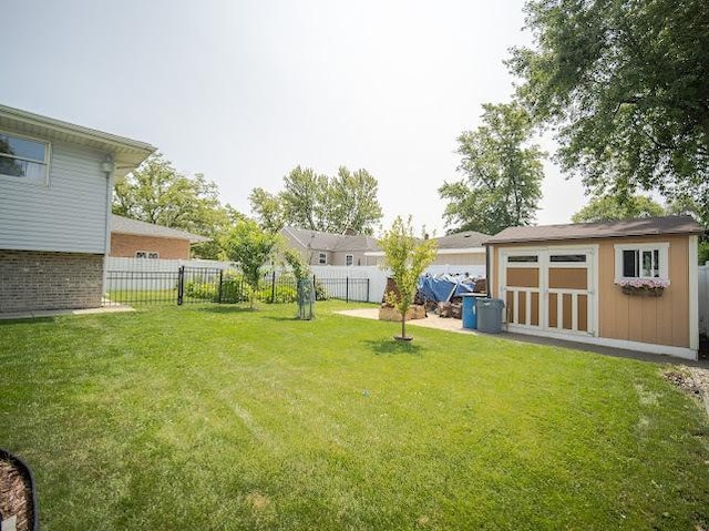 view of yard with a storage shed, an outdoor structure, and a fenced backyard