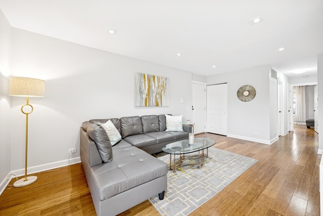 living room with light wood finished floors, baseboards, and recessed lighting