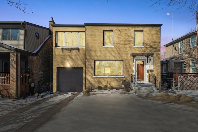 view of front facade featuring an attached garage, driveway, and brick siding