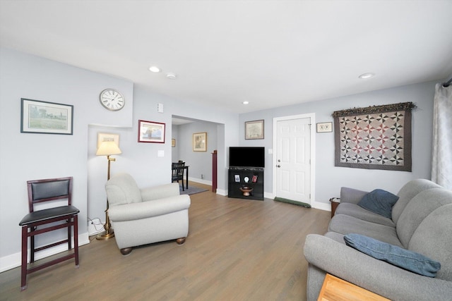 living area with baseboards, wood finished floors, and recessed lighting