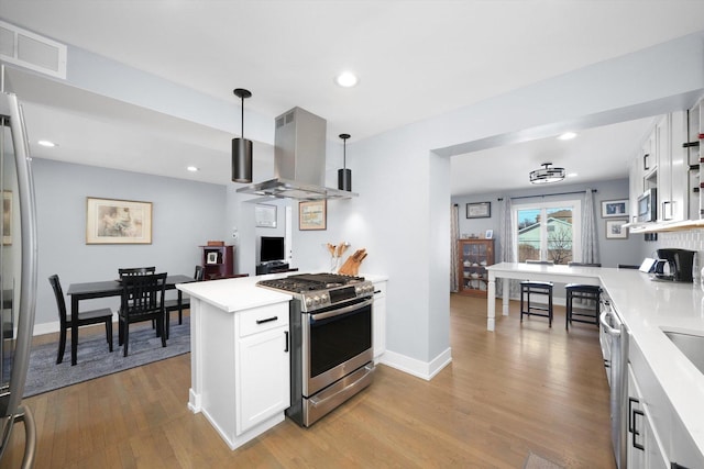 kitchen with stainless steel appliances, light wood-type flooring, visible vents, and island exhaust hood