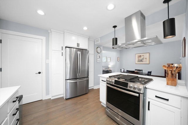 kitchen featuring white cabinets, wood finished floors, island exhaust hood, stainless steel appliances, and light countertops