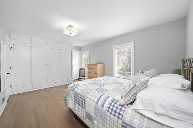 bedroom with a closet, visible vents, and wood finished floors