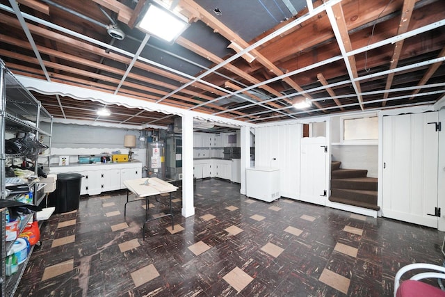 unfinished basement with water heater, stairway, and dark floors