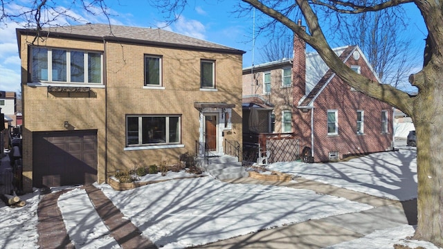 view of front facade featuring driveway, brick siding, and an attached garage