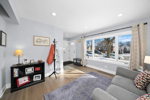 living room featuring recessed lighting, visible vents, baseboards, and wood finished floors