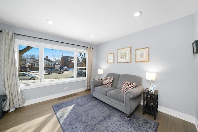 living area featuring recessed lighting, visible vents, baseboards, and wood finished floors