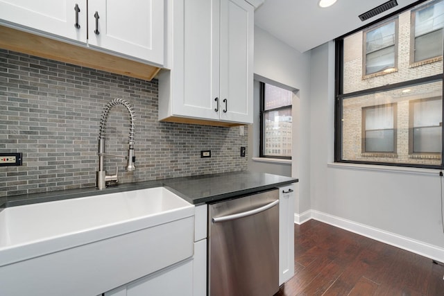 kitchen featuring a sink, dark countertops, backsplash, baseboards, and dishwasher