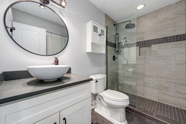 full bath with tile patterned floors, toilet, vanity, and walk in shower