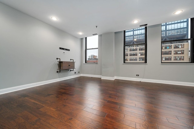 spare room with recessed lighting, baseboards, and wood finished floors