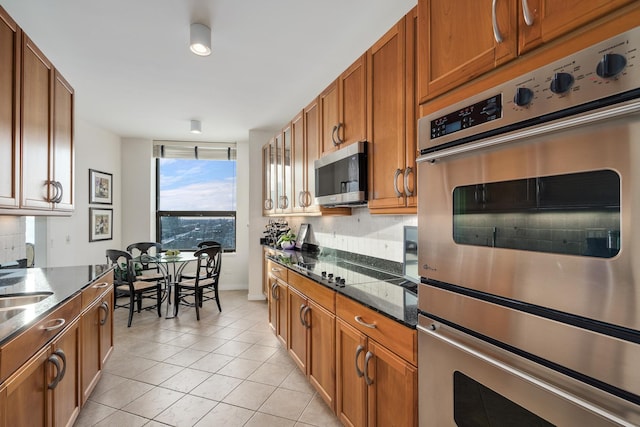 501 N Clinton St Unit 1705, Chicago, IL 60654 - kitchen featuring appliances with stainless steel finishes, brown cabinetry, and light tile patterned floors