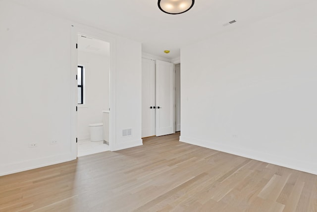 spare room with baseboards, visible vents, and light wood finished floors