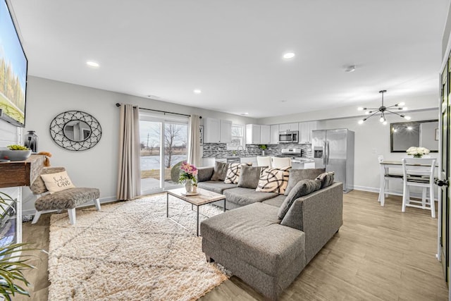 living room with light wood-type flooring, baseboards, and recessed lighting