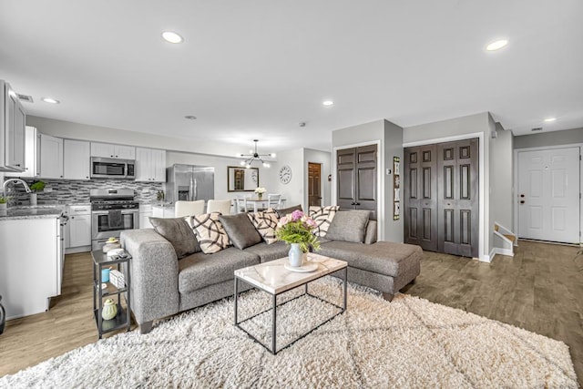 living area featuring baseboards, wood finished floors, and recessed lighting