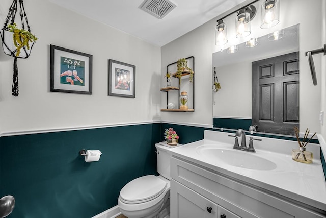 bathroom with visible vents, vanity, and toilet