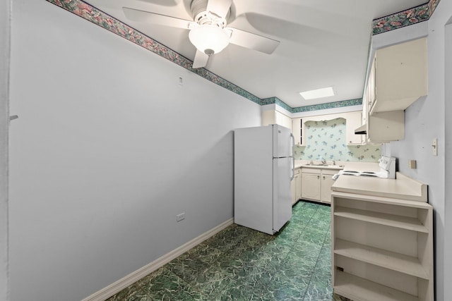 kitchen with white appliances, a sink, a ceiling fan, baseboards, and light countertops