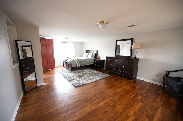 bedroom with baseboards, visible vents, and dark wood finished floors