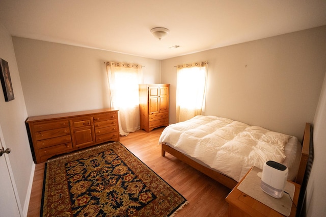 bedroom featuring light wood finished floors and visible vents