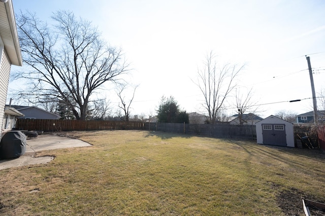 view of yard featuring an outbuilding, a storage shed, a patio area, and a fenced backyard