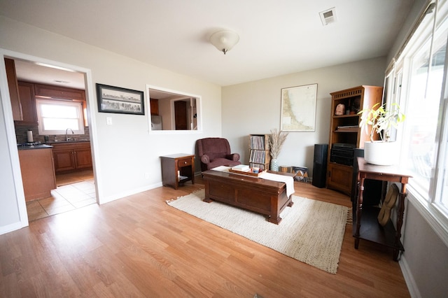 living area with light wood finished floors, baseboards, and visible vents