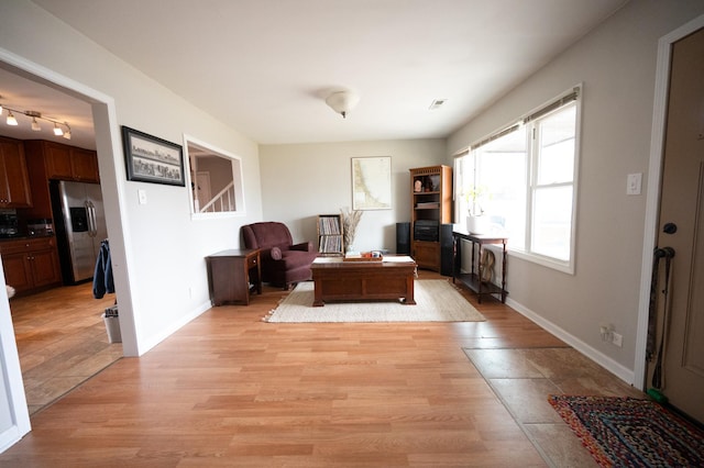 sitting room featuring light wood finished floors, visible vents, and baseboards