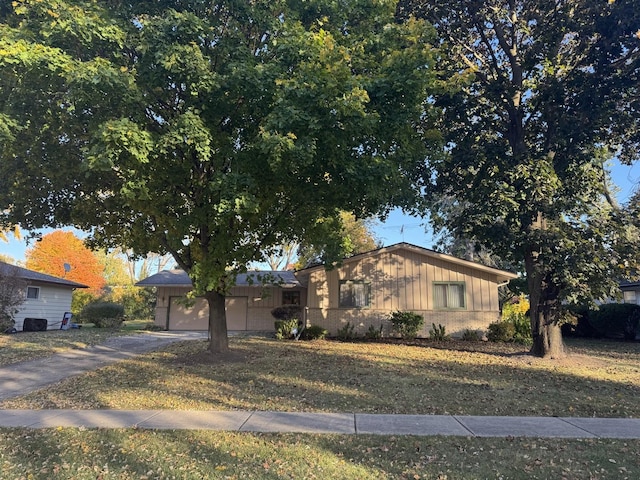 ranch-style home with driveway, an attached garage, board and batten siding, and brick siding