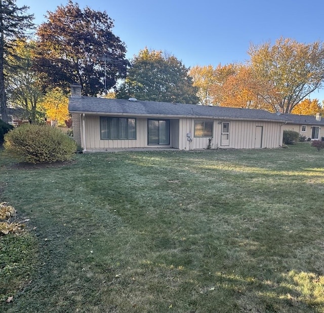 view of front of property with board and batten siding and a front lawn