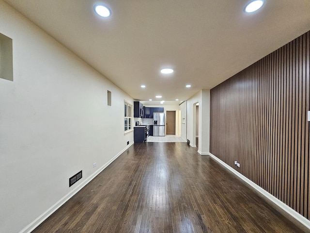 unfurnished living room featuring dark wood-style floors, recessed lighting, and baseboards