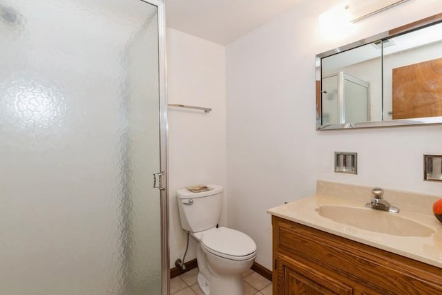 bathroom featuring vanity, a shower stall, toilet, and tile patterned floors